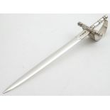 A silver novelty silver paper knife in the form of a basket hilt rapier sword. Hallmarked