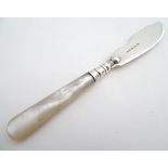 A silver butter knife with mother of pearl handle. Hallmarked Birmingham 1907 maker G E Walton & Co.
