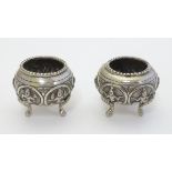 A pair of white metal salts with deity decoration. Probably Indian 1 3/4" wide Please Note - we do