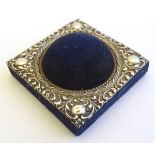 A blue velvet hat pin / pin cushion of squared form with domed centre and having embossed silver