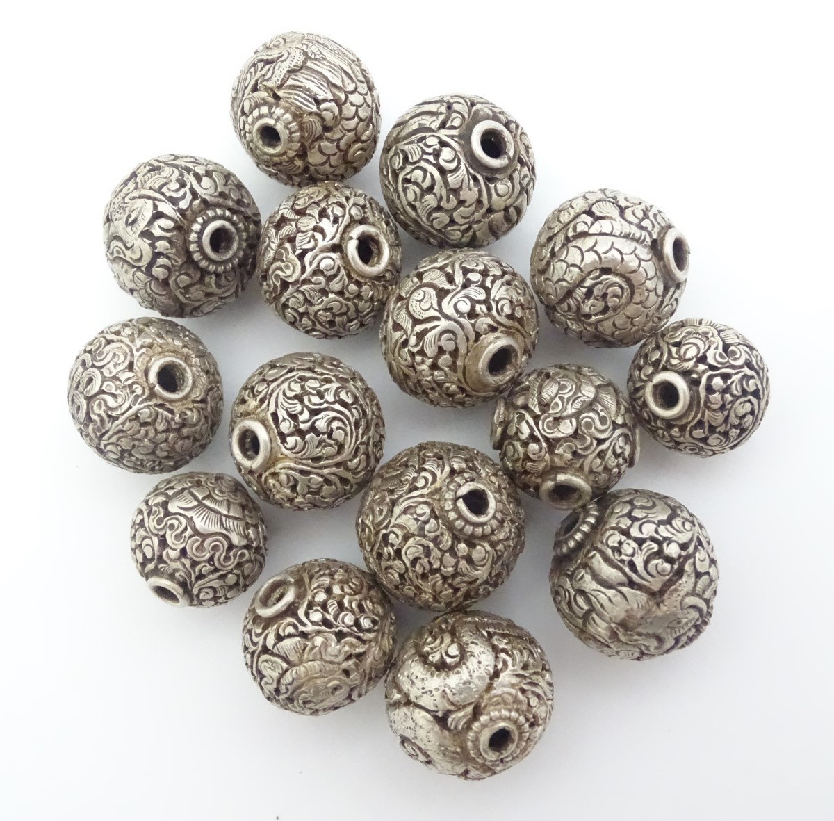14 assorted white metal beads with various acanthus scroll and scrolling dragon decoration. The