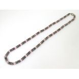 A silver and white metal necklace set with pink cats eye beads. Approx 16'' long Please Note - we do