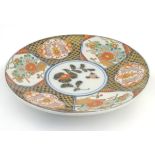 A Japanese Imari charger with panelled decoration decorated with flowers and scrolling foliage, with