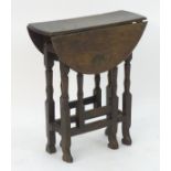 A small 18thC oak gate leg table of peg jointed construction with drop flaps opening to form an oval