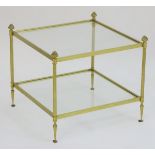 A 20thC two tier gilt brass and glass coffee table standing on turned tapering feet. 23'' wide x