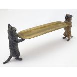 A 21stC novelty standish supported at either end by a cold painted cat and dog on hind legs. The