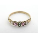 A 19thC yellow metal ring set with emeralds, garnets ans white stone. ring size approx size P Please