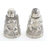 A pair of Mexican silver pepperettes , the glass bottles with silver overlay having engraved