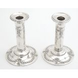 A matched pair of silver candlesticks with bow and swag decoration, hallmarked Birmingham 1908,