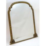 A late 19thC carved overmantle mirror with a shaped frame decorated with foliate detailing. 45''