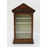 A 20thC mahogany glazed cabinet with a pediment top and moulded decoration.