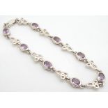 A silver bracelet set with oval amethysts. approx 7" long Please Note - we do not make reference