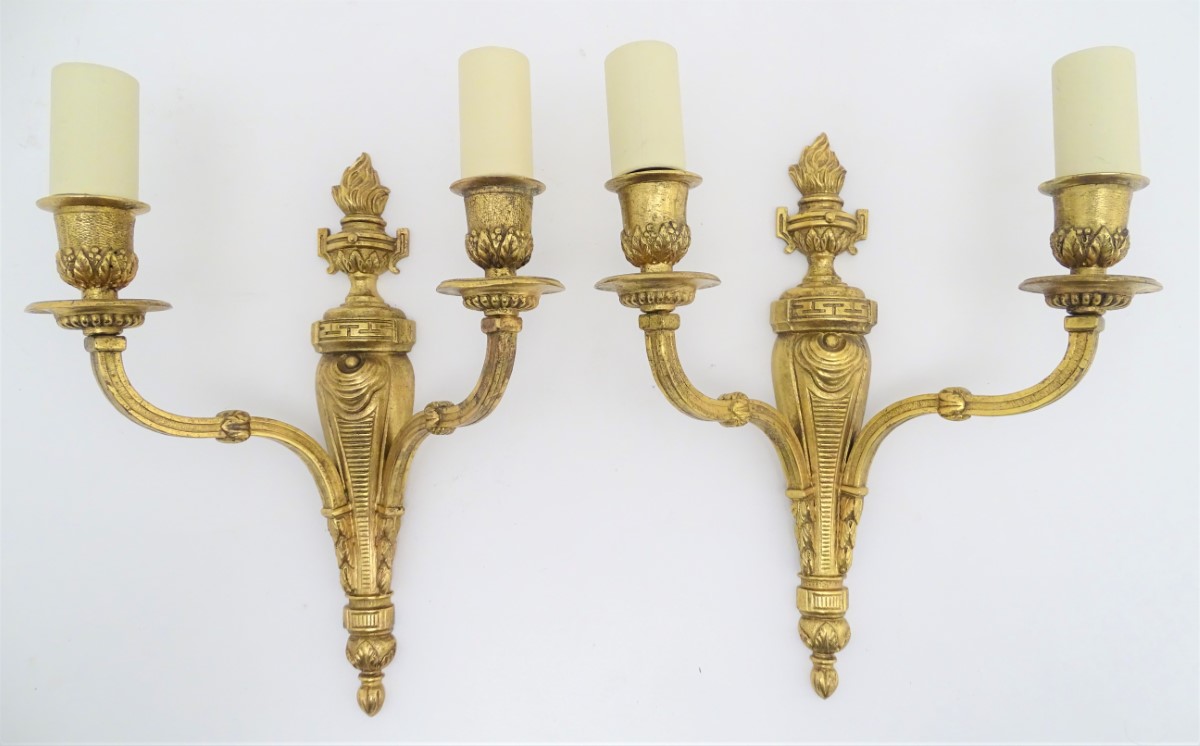 A pair of gilt metal twin branch wall sconces with flaming urn decoration. Together with four