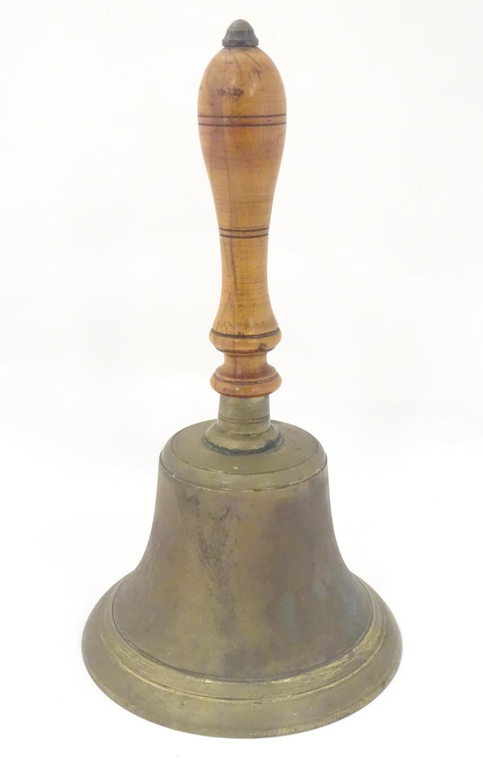 A 19th / 20thC large hand bell with a turned wooden handle and incised banded decoration. Approx. 14