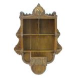A c.1936 oak hanging shelf with a carved frame, walnut clock face, graduated shelves and a carved