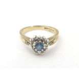 A 9ct gold ring set with central heart cut aquamarine bordered by diamonds. Ring size approx L.