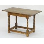 An 18thC oak occasional table with a planked top above bobbin turned supports terminating in block
