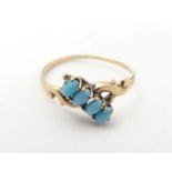 A 9ct gold ring set with four turquoise cabochon. Ring size approx F 1/2 Please Note - we do not
