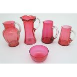 An assortment of 19thC cranberry glass jugs, together with a cranberry glass bowl. The largest 9"