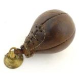 An mid-20thC leather Boxing gym punch ball, with brass loop and ceiling mount, 8" long Please Note -
