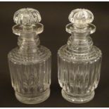 A matched pair of Georgian cut glass squat decanters, with fluted bodies and fan stoppers