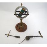 An early-20th electro-magnetic Geissler tube rotating device, mounted on a circular mahogany base,