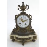 A 19thC French mantle clock, of brass construction with white marble base, urn finial and ormolu