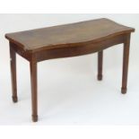 A late 18thC / early 19thC mahogany serving table with a serpentine and cross banded top above