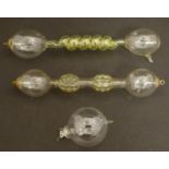 Three boxed Geissler tubes, variously formed of yellow and clear glass with spirals, spherical and