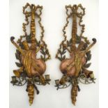 A pair of 20thC Italian style carved wood wall sconces with crossed violin and horn, foliate and bow