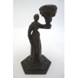 A 19thC bronze figure of a woman holding a vase aloft on a hexagonal base with foliate decoration.