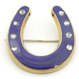 A late 19thC / early 20thC gilt metal brooch formed as a horseshoe with blue enamel decoration and