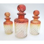 A c1920s graduated trio of Baccarat crystal / glass 'rose tiente' dressing table bottles, each