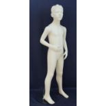 A later 20thC lifesize shop mannequin formed as a boy, on a circular glass stand. Approx. 52" tall