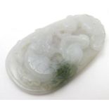 An Oriental carved jade pedant depicting stylised birds, figure etc. 2" long Please Note - we do not