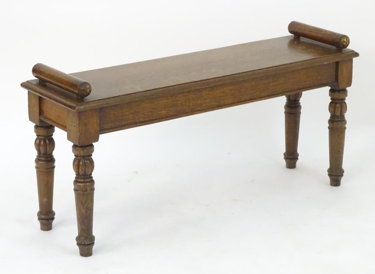 A late 19thC / early 20thC oak hall bench raised on turned tapering legs with gadrooned sections.