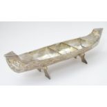 A white metal model of a canoe / kayak / bowl / barge. Approx 11" long Please Note - we do not