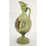 A late 19thC Continental olive green glass ewer, of circular form with central void, decorated