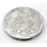 A Continental white metal .833 powder compact with engraved decoration. Approx. 2 1/4" diameter.
