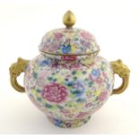 A Chinese famille rose millefiore twin handled pot and cover decorated with a profusion of flowers