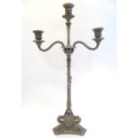 A Victorian silver plate three branch candelabra, with engraved armorial to base, lion's paw feet