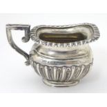 A silver cream jug hallmarked Birmingham 1909 maker TW. 4" long Please Note - we do not make