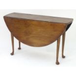 A 19thC mahogany drop leaf table with turned tapering legs terminating in pad feet. 48" long x 16"