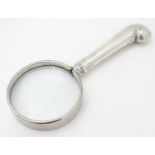 A silver handled magnifying glass. Approx 5" long Please Note - we do not make reference to the