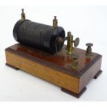 An early-20thC induction coil for Geissler tube rotator devices, mounted to a mahogany base, 4 3/