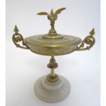 A 20thC brass lidded tazza with scrolling foliate decoration and a bird finial. Mounted on a