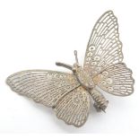 A white metal brooch formed as a butterfly 1 1/2" wide Please Note - we do not make reference to the