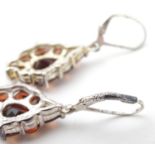 A pair of silver drop earrings set with garnet coloured stones. Approx 1 2/4" long Please Note -