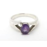 A silver ring set with central amethyst. Ring size approx Q Please Note - we do not make reference