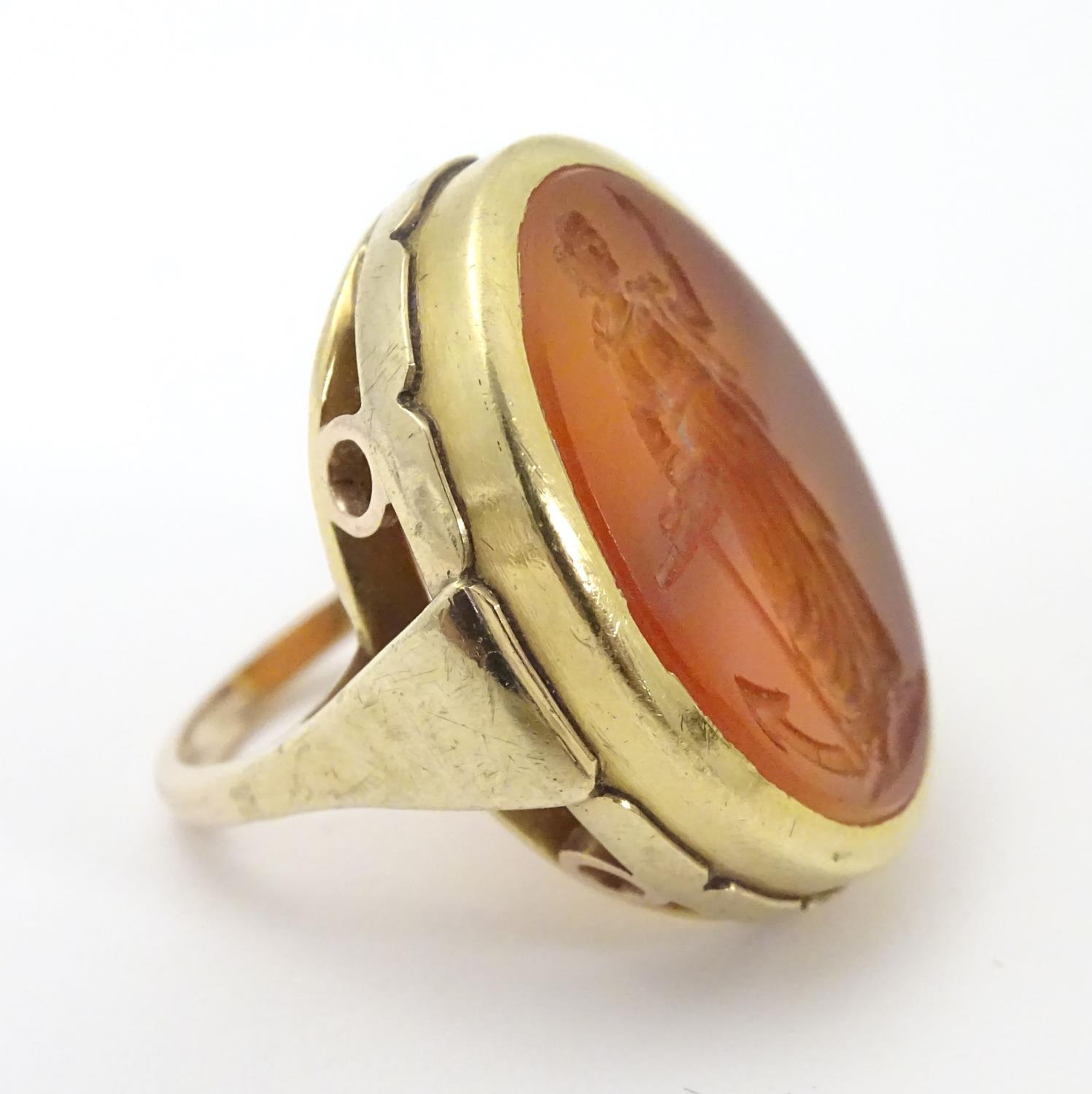 A 9ct gold signet ring set with large carved carnelian seal to centre depicting the personification